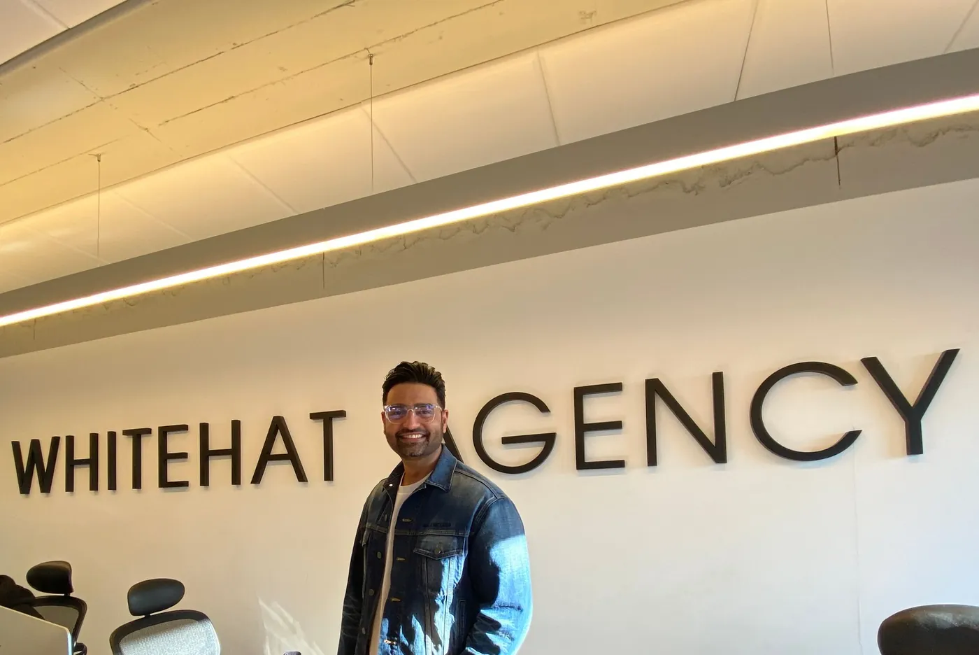 Shuey Shujab, founder of Whitehat Agency, in front of the Whitehat Agency sign